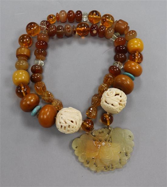 A string of beads with pierced jade wu fu pendant and dual pierced carved ivory balls, one with fish, the other with dragon